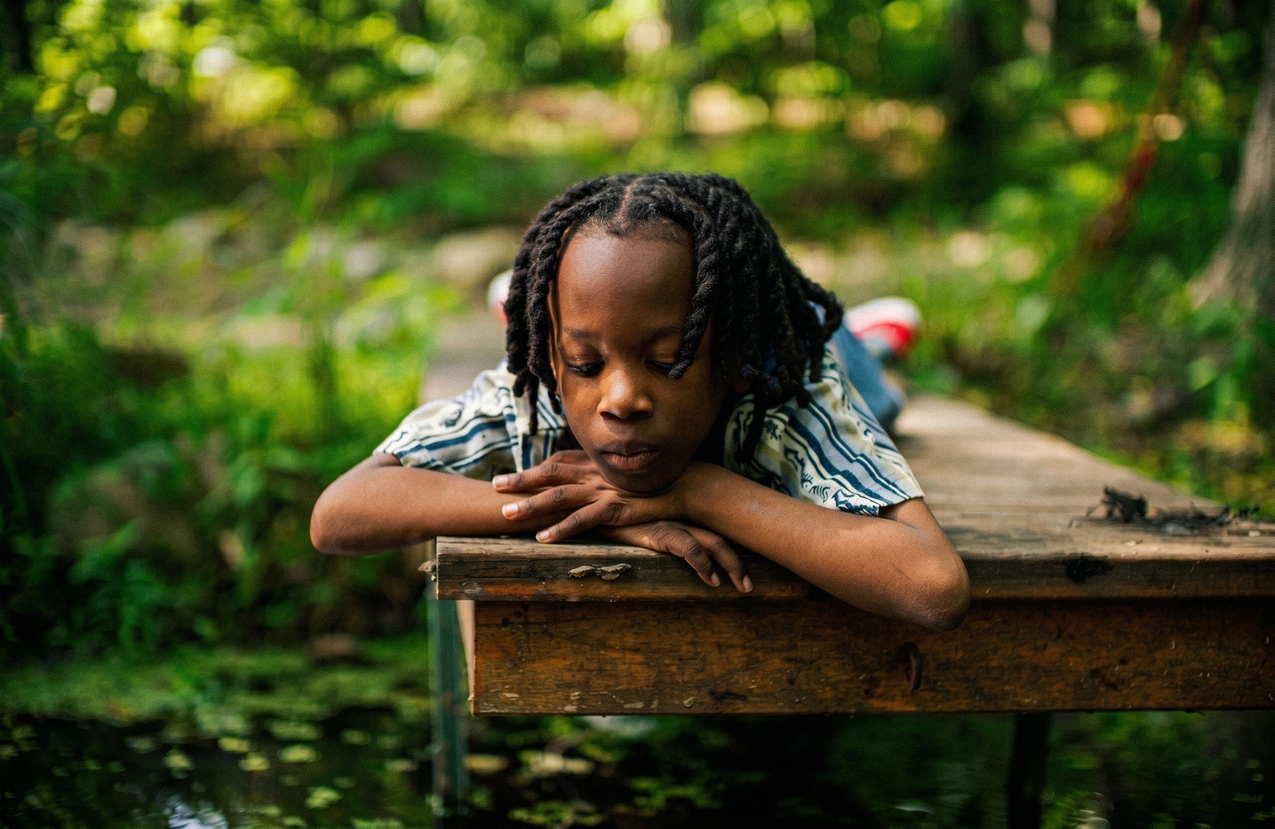 A young boy rests his chin on a wooden dock — Yellow-Tail